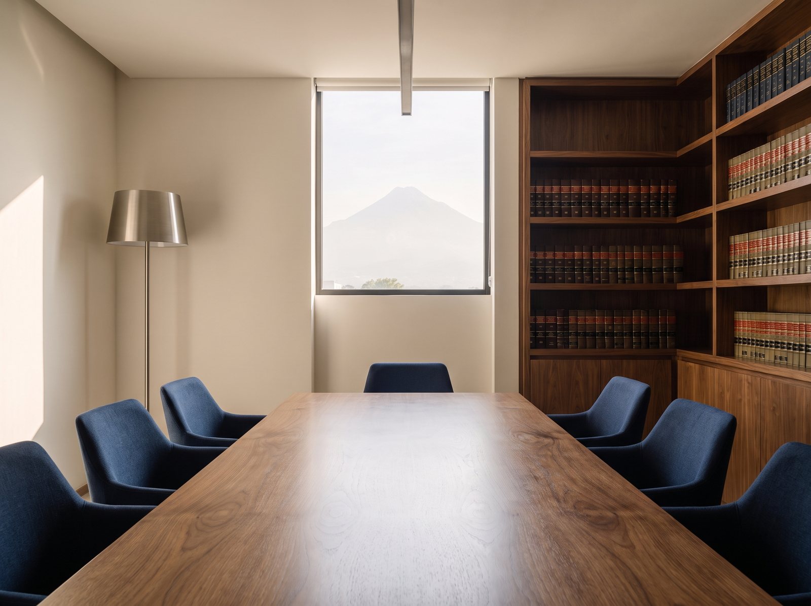 Sala de juntas del despacho con mesa de nogal y códigos legales
